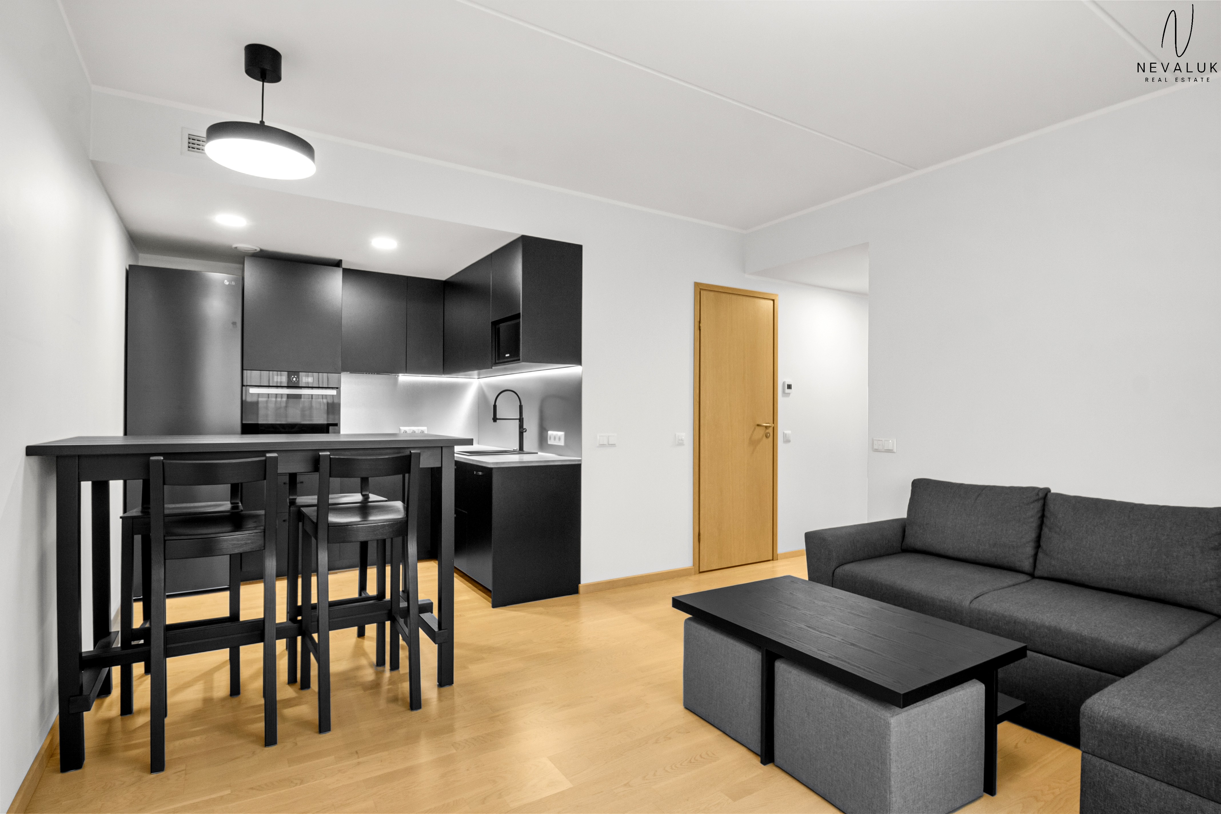 Kaasaegne musta värvi köögimööbel koos integreeritud tehnika ja söögilauaga