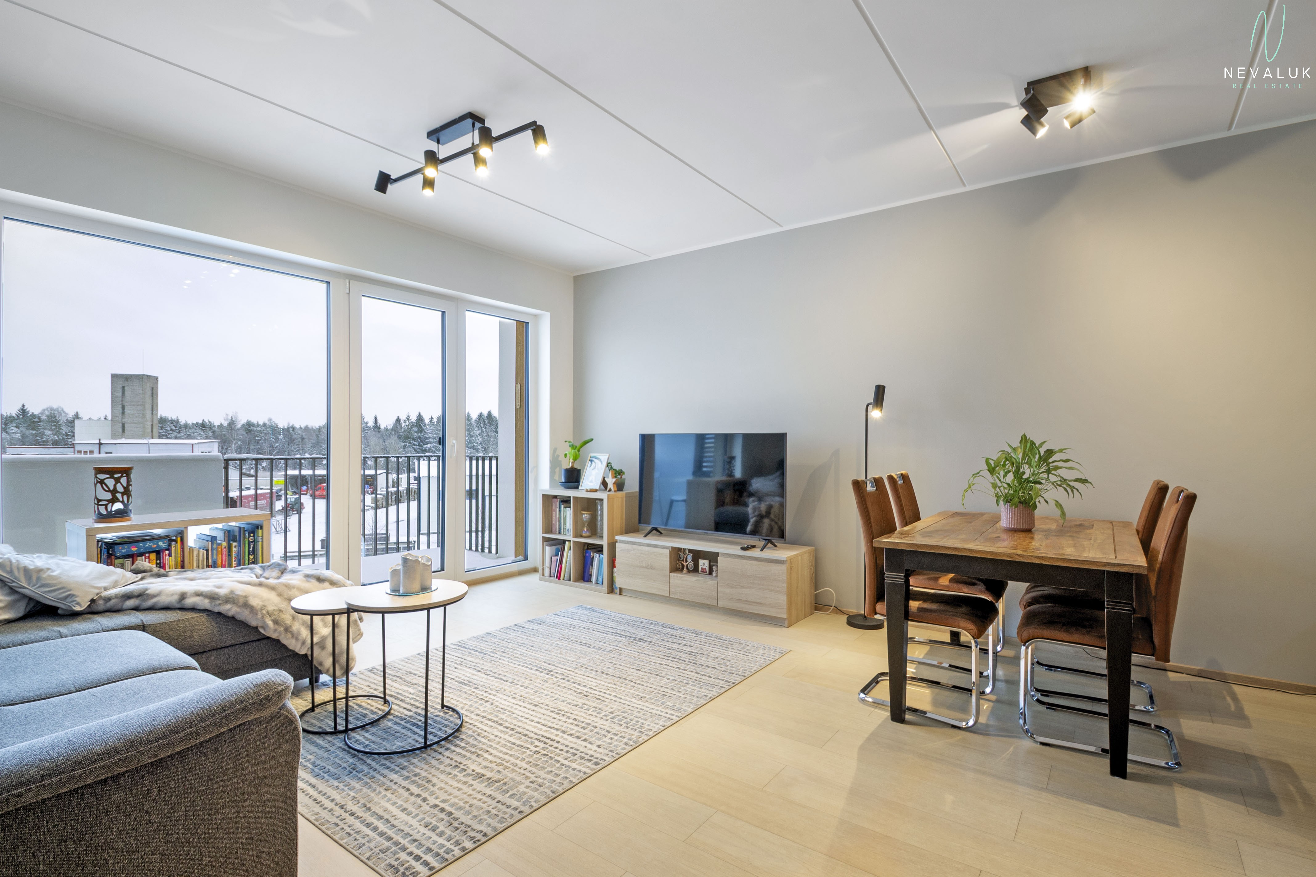 Vaade elutoale, kus on näha telerialus, söögilaud ja pääs rõdule