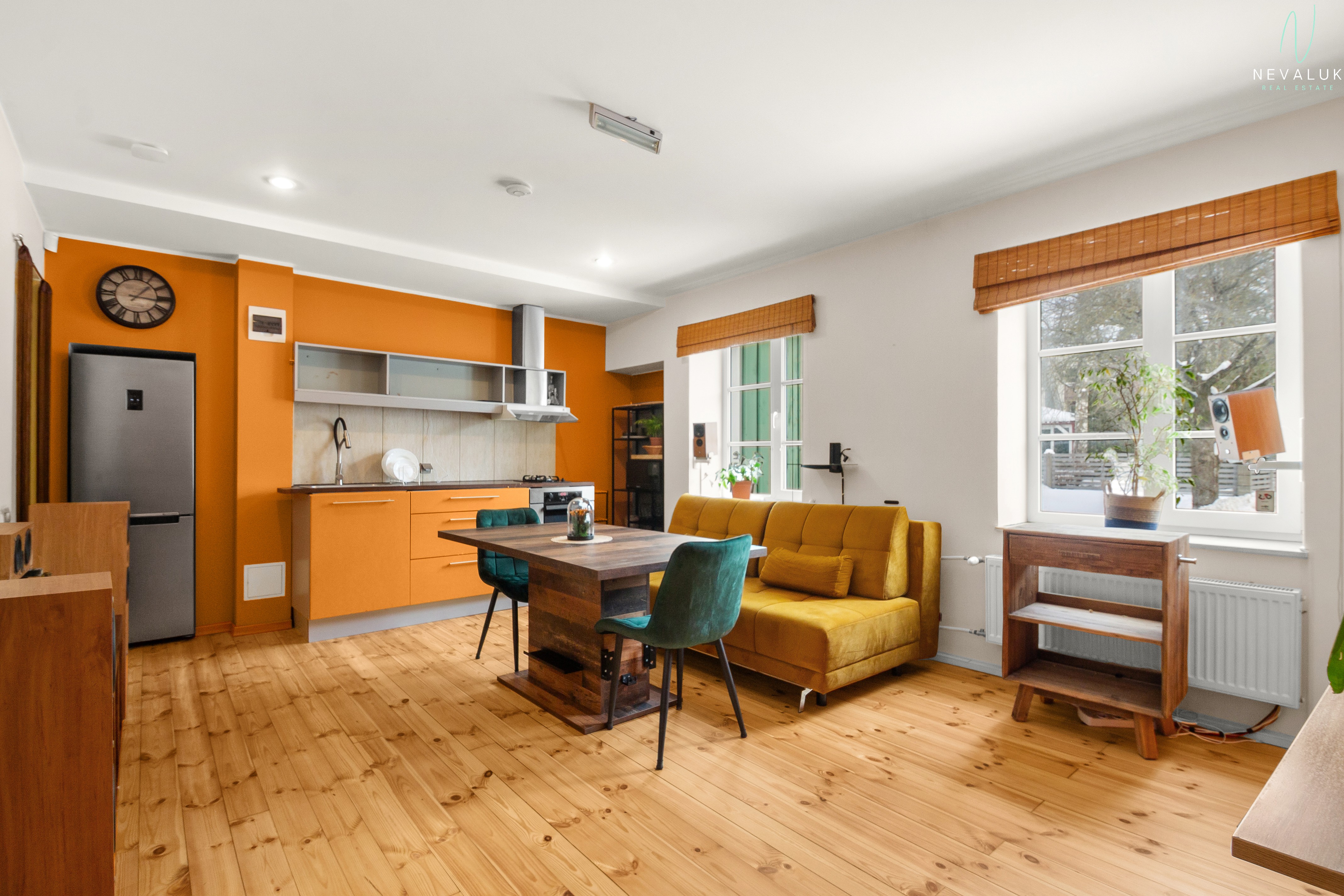 Üldvaade elutoale ja köögile, rõhutades oranzi aktsentseina ja valgusküllasust