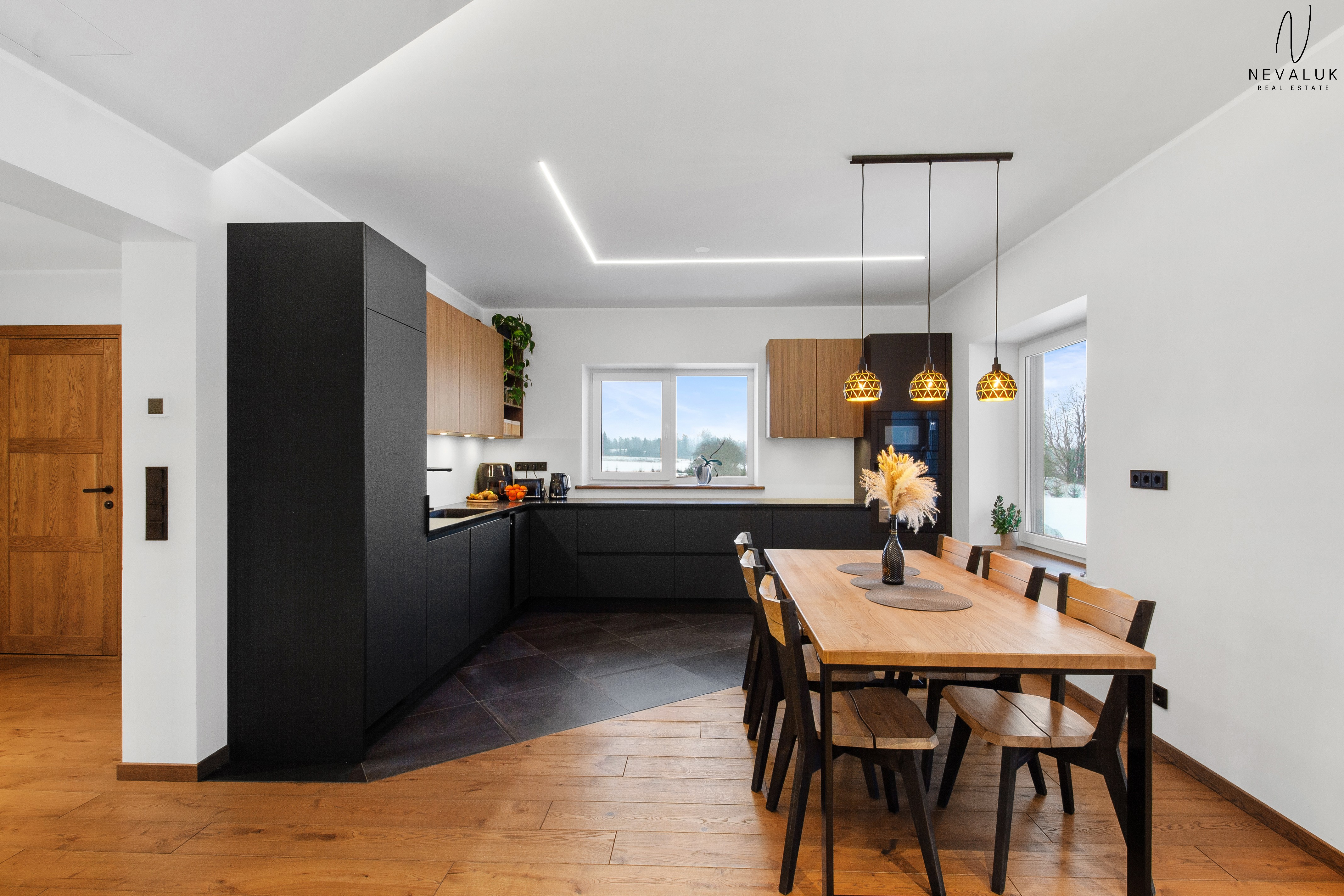 Panoraamvaade köögist elutoa suunas, rõhutades avatud planeeringut ja tammeparketti